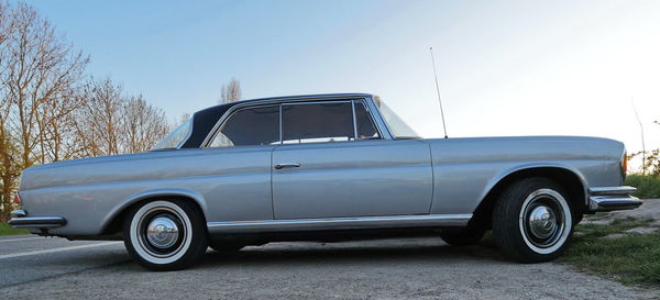 Vintage car parked on road against clear blue sky