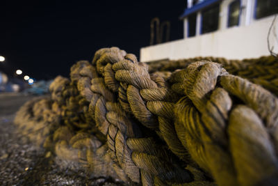 Close-up of rope tied up on bollard at night