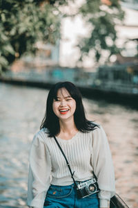 Portrait of smiling young woman standing outdoors