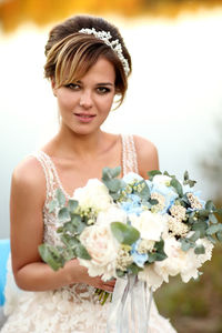 Bride with a bouquet of flowers on the background of the river