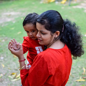 Loving mom carrying of her baby at society park. bright portrait of happy mum holding child