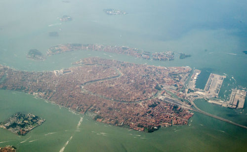 High angle view of city by sea against sky
