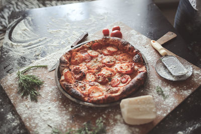 Pizza and hands top view with flour, dark background and toning