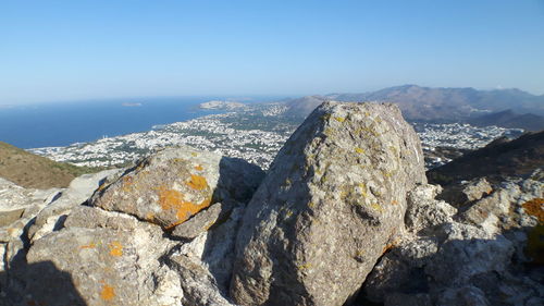 Close-up of rocks by sea against clear sky