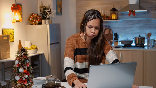 Young woman using mobile phone at home