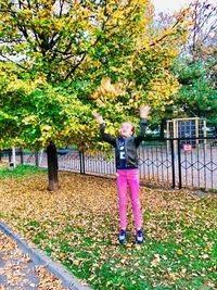 Full length of girl with autumn leaves in park