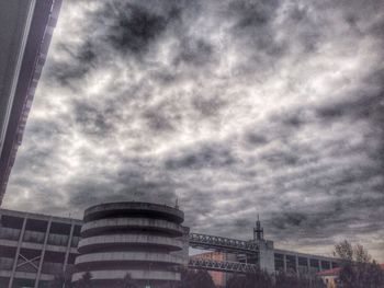 Low angle view of modern building against cloudy sky