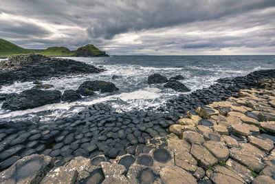 Scenic view of rocks on beach against sky