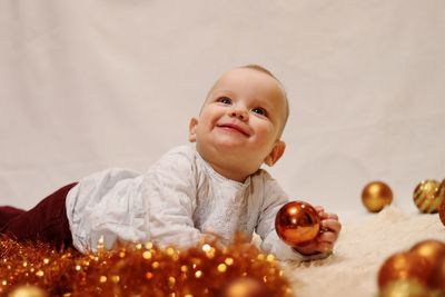 Smiling girl looking away while holding christmas bauble