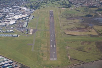 High angle view of airplane flying over agricultural field