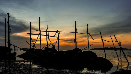 Silhouette sailboats on sea against sky during sunset