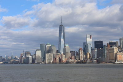 Modern buildings in city against cloudy sky