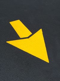 Close-up of arrow sign on road