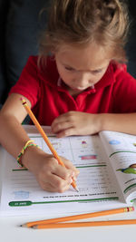 Boy holding book on table