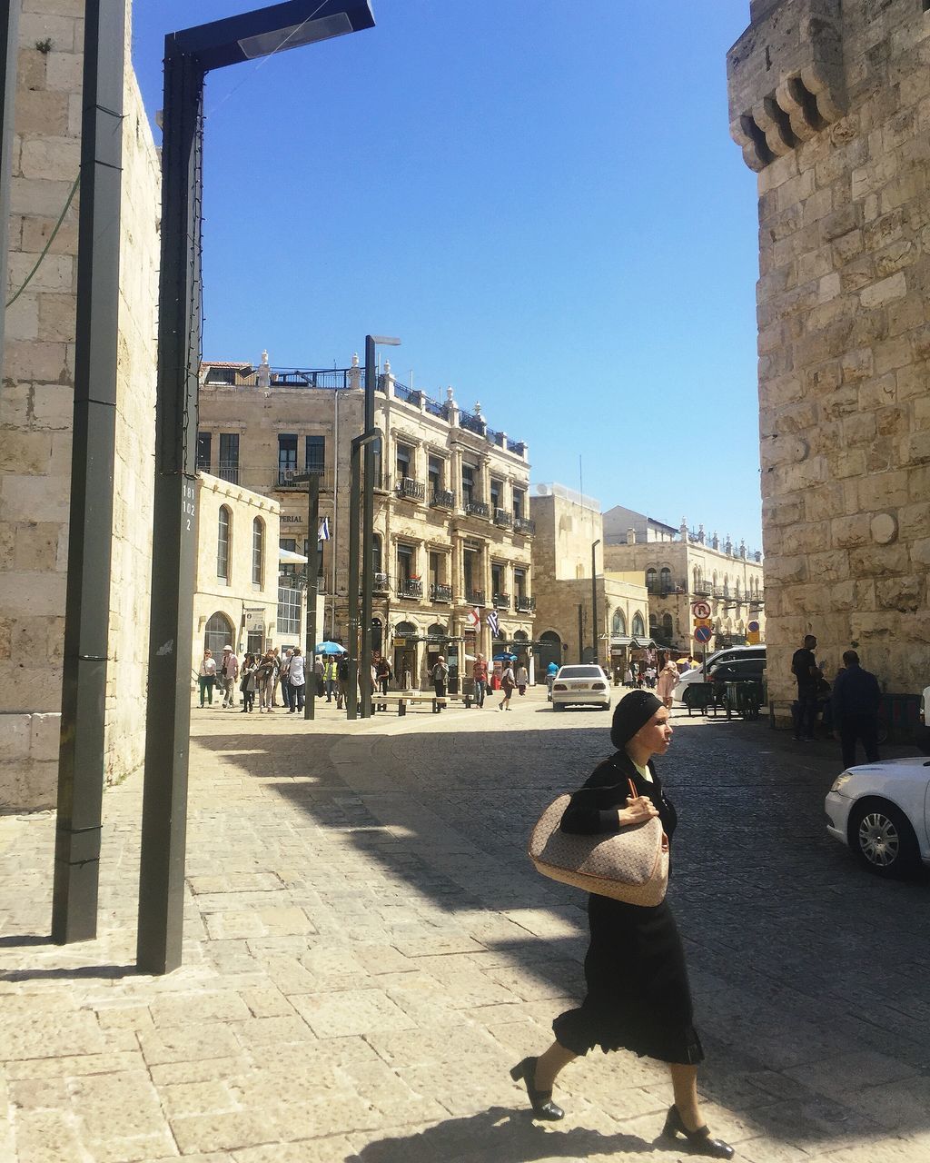 PEOPLE ON STREET AGAINST BUILDING IN CITY