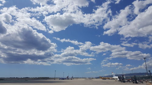 Airplane on airport runway against sky