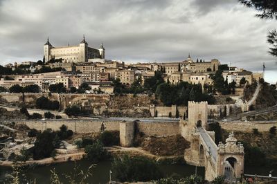 Low angle view of buildings at toledo against cloudy sky
