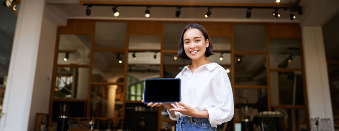 Portrait of young woman using digital tablet