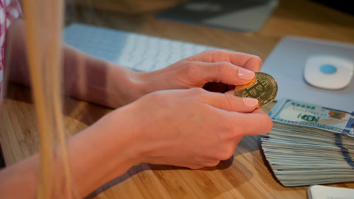 High angle view of woman hand holding tea cup on table