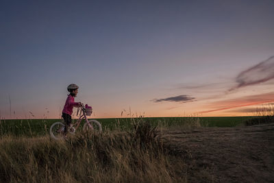 Full length of woman on field against sky during sunset