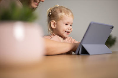 Young woman using laptop while sitting on table