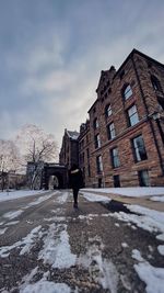 Man walking on snow covered buildings in city