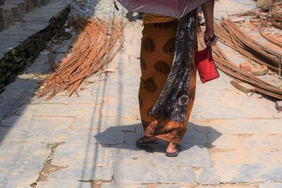 Low section of woman standing on footpath