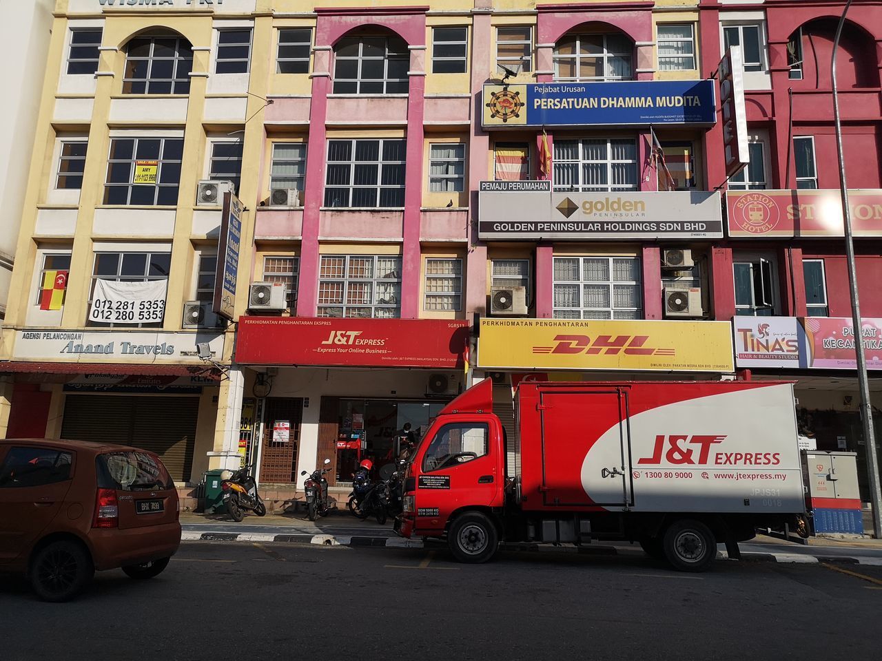 CARS ON ROAD AGAINST BUILDINGS