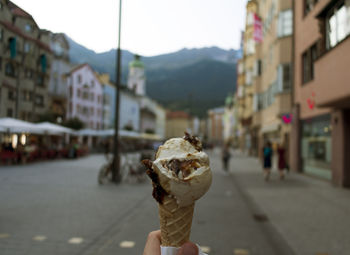 Woman holding ice cream cone in city