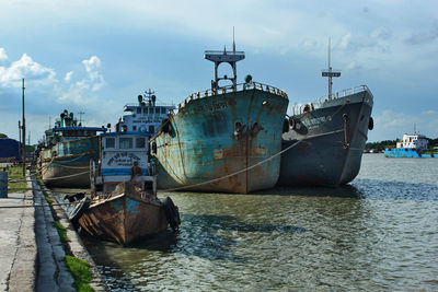 Sailboats moored on sea against sky