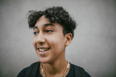 Smiling curly haired teenage boy wearing chain