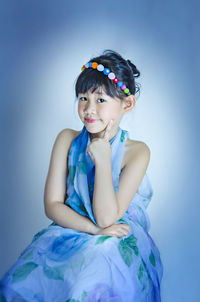 Portrait of cute girl against blue background