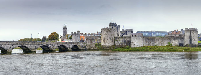 Bridge over river against buildings in city