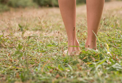 Low section of woman standing on field