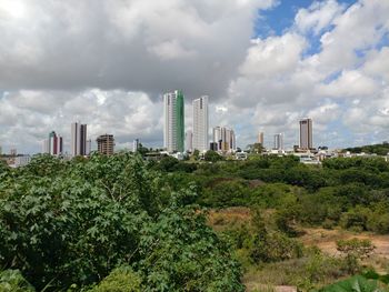 View of cityscape against cloudy sky