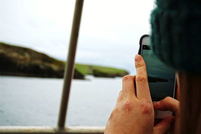 Close-up of person photographing through mobile phone