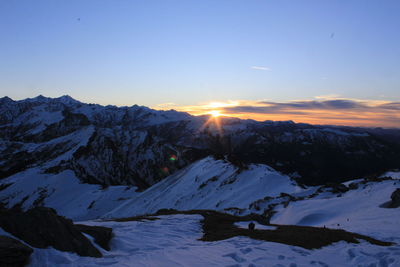 Scenic view of snowcapped mountains against sky during sunset