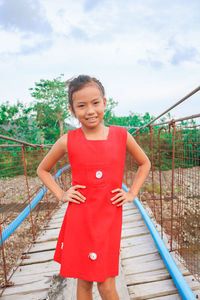 Portrait of smiling girl standing against sky