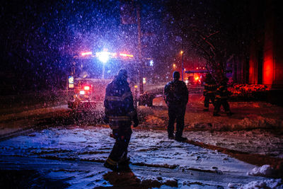 People on wet street in city at night