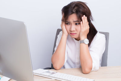 Portrait of woman using mobile phone while sitting on table