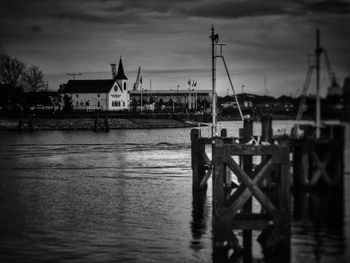 Boats moored at harbor against sky