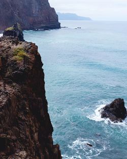 Rock formations by sea against sky