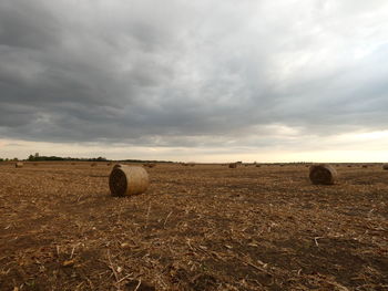 Hay bales on field against sky