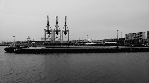 Commercial dock by river against clear sky