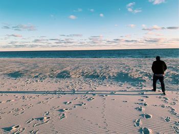 Rear view of woman standing on beach