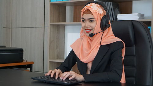 Portrait of young woman using laptop at table