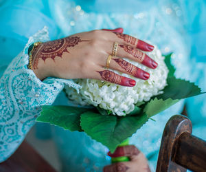 Midsection of bride holding bouquet