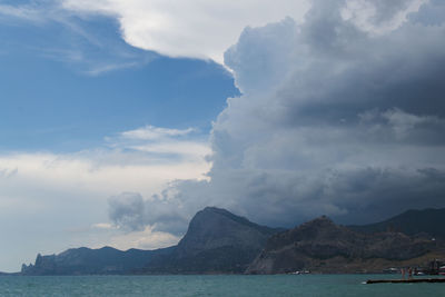 Scenic view of sea and mountains against sky