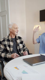 Nurse talking with senior man in rehab