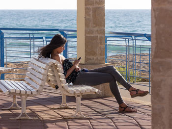 Woman texting on bench